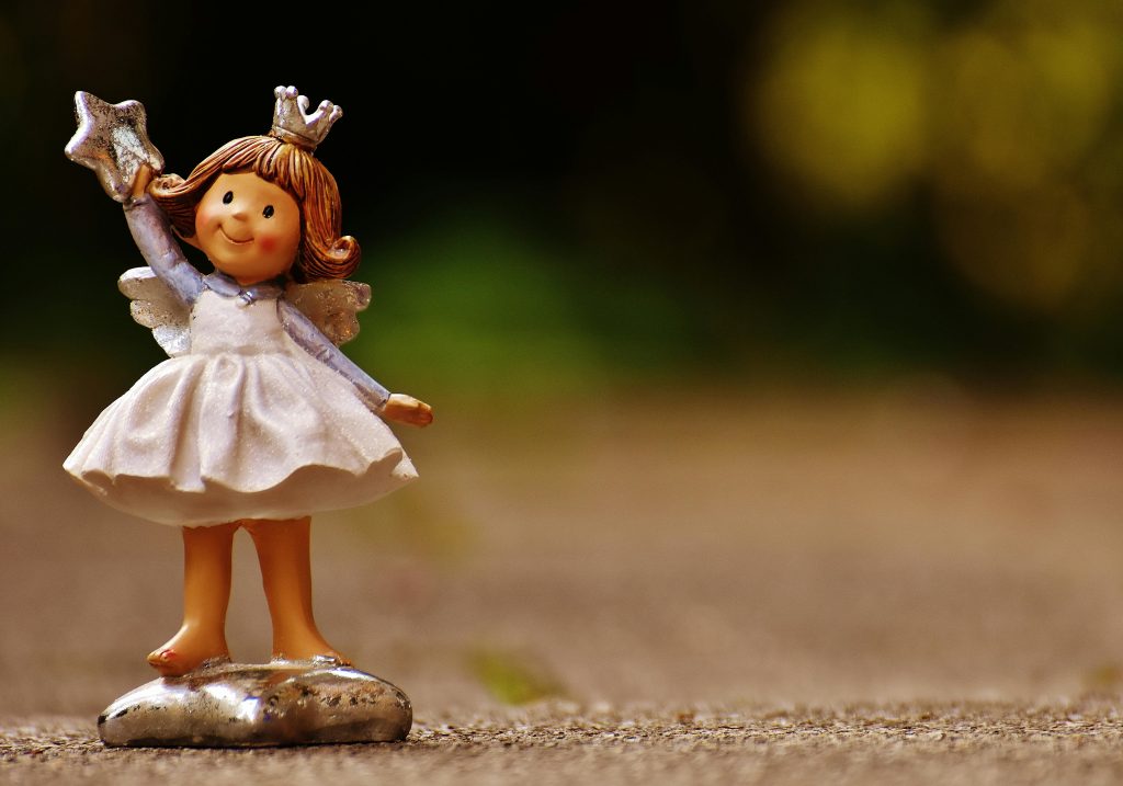 Delightful angel figurine holding a star, set against a blurred natural outdoor background. Perfect for holiday decor.