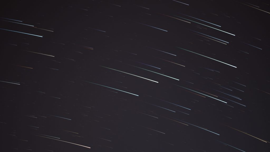 A mesmerizing long exposure photograph capturing streaking stars in the night sky.
